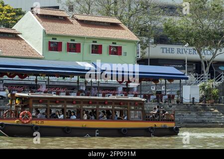 Singapour, Singapour, Asie, Asie ; BATEAU de croisière sur le fleuve Singapour avec bâtiments côtiers en arrière-plan. Ausflugssschiff auf dem Fluss. Banque D'Images