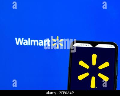 Sur cette photo, le logo Walmart, Inc. Est affiché sur un smartphone et en arrière-plan. Banque D'Images