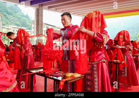 (210520) -- CHONGQING, le 20 mai 2021 (Xinhua) -- les épouses et les marié sont vus lors d'une cérémonie collective de mariage au lieu principal de la célébration de la Journée mondiale de l'abeille en Chine, dans le canton de Zhongyi, comté autonome de Shizhu Tujia, dans le sud-ouest de la Chine, Chongqing, le 20 mai 2021. Le 20 mai marque la Journée mondiale des abeilles. Cette année, la célébration de la Journée mondiale des abeilles en Chine, qui a pour thème « Honeybee, Big Dreams, UN programme de revitalisation rurale », s'est tenue dans le canton de Zhongyi, dans le comté de Shizhu.ces dernières années, l'industrie de l'apiculture en Chine a fait beaucoup de pratiques remarquables dans la promotion de la réduction de la pauvreté et de la revitalisation rurale Banque D'Images