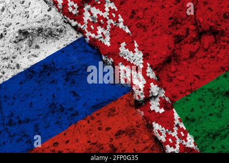 Concept de la relation entre la Russie et la Biélorussie avec des drapeaux peints sur un mur avec une fissure Banque D'Images