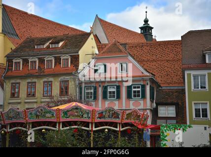 Vue panoramique sur les bâtiments de style baroque et le carrousel peint à la main à la foire de Noël pour enfants de la rue Neutorgasse à Graz, en Autriche Banque D'Images