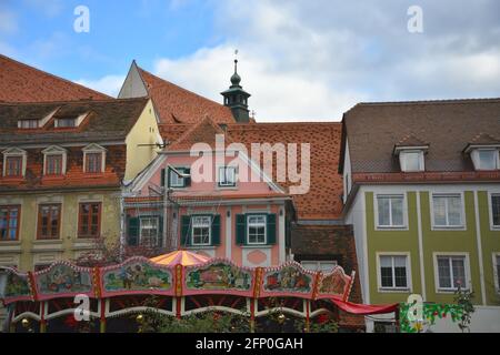 Vue panoramique sur les bâtiments de style baroque et le carrousel peint à la main à la foire de Noël pour enfants de la rue Neutorgasse à Graz, en Autriche. Banque D'Images