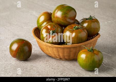 Panier de tomates entières fraîches et rayées rouges et vertes mûres gros plan Banque D'Images