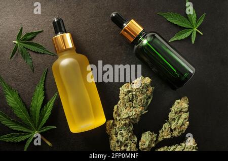 Extrait de marijuana en cosmétologie. Fleurs de cannabis, huile de cbd, cosmétiques organiques. Revêtement plat, fond noir. Détente à la maison, détente au spa, passe-temps Banque D'Images