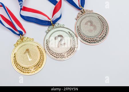 Médailles d'or, d'argent et de bronze pour la première, la deuxième et la troisième place, sur fond blanc. Jeux olympiques et concept sportif. Banque D'Images