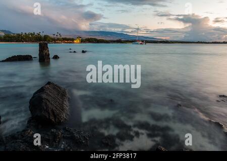 Lava exposée avec Beach Club de l'autre côté de la baie Anaeho'omalu sur Waikoloa Beach, Waikoloa, Hawaii, États-Unis Banque D'Images