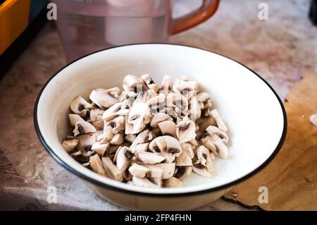 Une assiette de champignons hachés sur une table de cuisine Banque D'Images