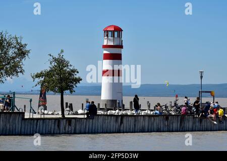 Podersdorf, Autriche - 029 mai 2021: Personnes non identifiées sur la jetée avec phare dans la station balnéaire sur le lac neusiedlersee, un voyage préféré dest Banque D'Images