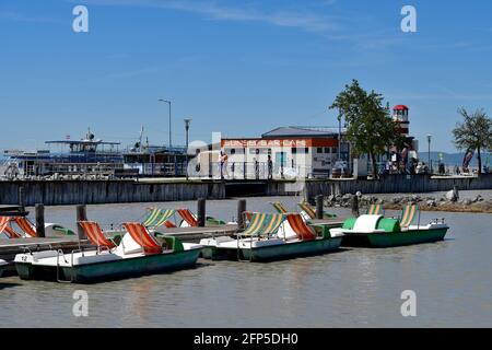 Podersdorf, Autriche - 029 mai 2021 : des personnes non identifiées et des bateaux pesaux sur la jetée avec phare dans la station balnéaire sur le lac neusiedlersee un préféré Banque D'Images