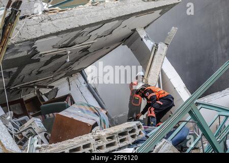 Gaza, Palestine. 15 mai 2021. Les pompiers ont éteint un incendie dans un bâtiment qui abritait l'Associated Press et un autre bureau des médias de la ville de Gaza.la frappe aérienne de samedi a eu lieu environ une heure après que l'armée israélienne ait ordonné aux gens d'évacuer le bâtiment. Il n'y avait pas d'explication immédiate pour la raison pour laquelle le bâtiment était visé. Crédit : SOPA Images Limited/Alamy Live News Banque D'Images