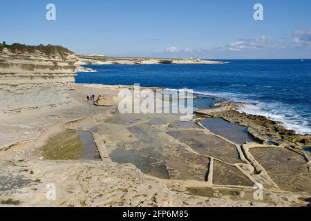 MARSAXLOKK, MALTE - 03 JANVIER 2020 : champs de sel traditionnels, mer Méditerranée et petite colline calcaire en arrière-plan près de la piscine de Pierre Banque D'Images