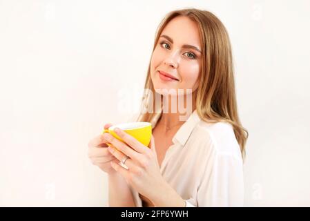 Femme adulte en robe fermant les yeux tout en ayant une tasse de café noir fraîchement préparé Banque D'Images