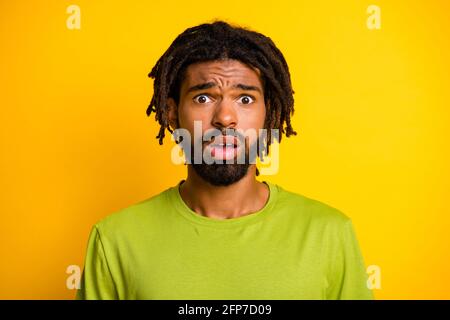 Portrait de déçu peur sombre peau gars regarder dans l'appareil photo vous vous sentirez isolé sur un fond jaune vif Banque D'Images