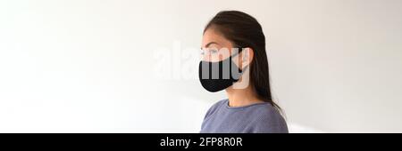 Femme asiatique portant un masque en tissu noir. Mode de vie décontracté des jeunes pendant une pandémie de coronavirus. Portrait de modèle ethnique de fille avec Banque D'Images