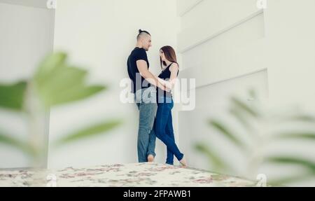 un jeune couple romantique qui s'embrasse dans la chambre et se regarde l'un l'autre Banque D'Images