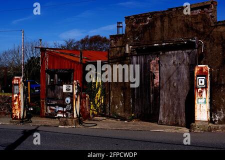 L'ancienne station-service a maintenant été désutilisée dans le village de Llanrug Gwynedd, au nord du pays de Galles. Les anciennes pompes à essence restent en place juste sur le trottoir Banque D'Images