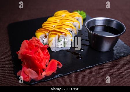 roulés avec du fromage et du concombre sur un tableau noir. Banque D'Images