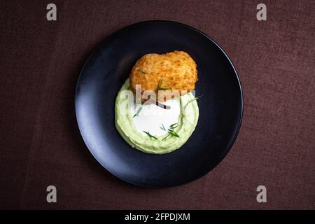 Côtelette de Kiev avec purée de pommes de terre sur une assiette noire. Banque D'Images