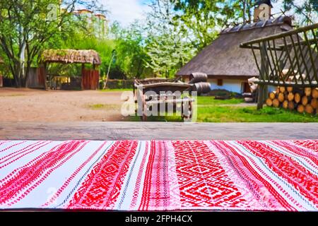 La table devant la cour rurale est recouverte de tissu rituel rushnyk ukrainien traditionnel avec des motifs brodés rouges et noirs, Mamajeva Slo Banque D'Images