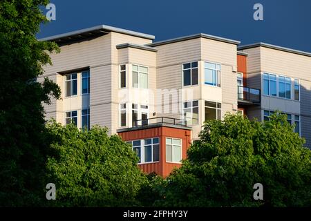 Redmond, WA, États-Unis - 19 mai 2021; Veloce immeuble d'appartements avec arbres verts dans le centre-ville de Redmond, Washington, dans des couleurs orange et crème Banque D'Images