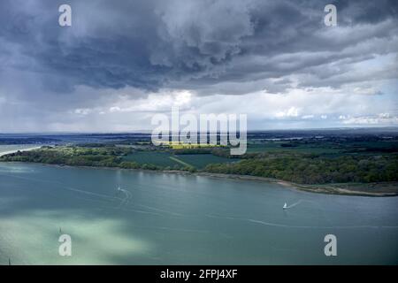 Les cumulus sombres orageux orageux au-dessus de la campagne et de l'estuaire du West Sussex près de Chichester Marina avec des bateaux à voile dans l'eau. Photo aérienne. Banque D'Images