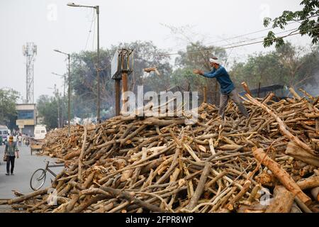 New Delhi, Inde. 09e mai 2021. Un homme vu au-dessus d'une énorme pile de bois de chauffage à utiliser dans les pyres funéraires pour les derniers droits des victimes Covid-19 à l'extérieur d'un crématorium à New Delhi. En une seule journée, l'Inde a enregistré 366,161 cas de covid-19 infectés frais et 3,754 décès dus à Covid-19. Crédit : SOPA Images Limited/Alamy Live News Banque D'Images