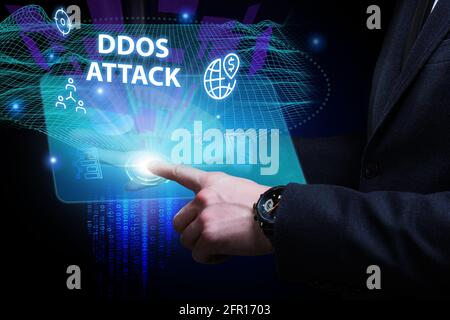 Concept commercial, technologique, Internet et réseau. Jeune homme d'affaires travaillant sur un écran virtuel du futur et voit l'inscription: Attaque DDoS Banque D'Images
