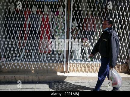 Vancouver, Canada. 20 mai 2021. Un homme passe devant un magasin fermé à Chinatown, Vancouver, Colombie-Britannique, Canada, le 20 mai, 2021. Après avoir souffert de la pandémie COVID-19 pendant plus d'un an, les entreprises de Chinatown, l'une des attractions touristiques de Vancouver, demandent de l'aide pour ramener les visiteurs. Credit: Liang Sen/Xinhua/Alay Live News Banque D'Images