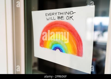 Courravirus Rainbow campagne peinture accrochée à la fenêtre d'accueil pour diffuser la positivité avec le message TOUT SERA OK en anglais. Royaume-Uni, États-Unis, Australie. Banque D'Images