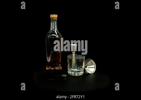 Vieux verre à fashon à côté de la bouteille avec des pierres à whisky Scotch entonnoir de mesure pour servir le liquide doré Banque D'Images