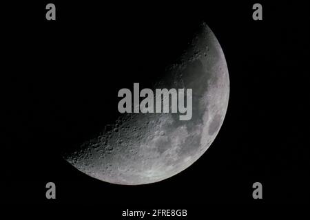 Vue sur une lune de gibbous épiée juste à côté d'une demi-lune. Banque D'Images