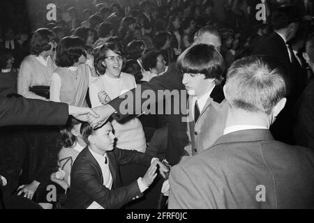 La police se joint à la main pour retenir les fans adoring tandis que Ringo Starr se promène au Washington Coliseum de Washington, D.C. où les Beatles jouaient dans leur premier concert américain le 11 février 1964. (ÉTATS-UNIS) Banque D'Images