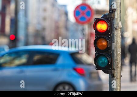 gros plan d'un petit sémaphore de trafic avec feu rouge contre le toile de fond de la circulation urbaine Banque D'Images