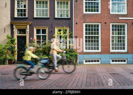 Cycliste cycliste cycliste cycliste femme enfant sur vélo moyens de transport populaires aux pays-Bas dans la rue de Delft, pays-Bas Banque D'Images