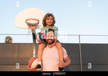 père et fils jouent au basket-ball. joyeux fête des pères. joyeux famille. papa et gamin jouent au basket-ball. Banque D'Images