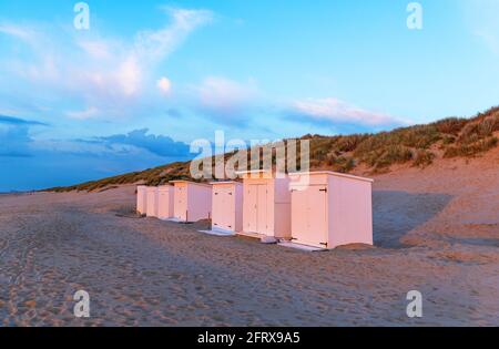 Cabines de plage au coucher du soleil près d'Ostende (Ostende), Bredene, Flandre Occidentale, Belgique. Banque D'Images