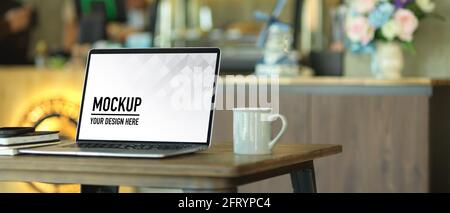 Vue rapprochée de l'espace de travail portable avec ordinateur portable, carnets et tasse à café Banque D'Images