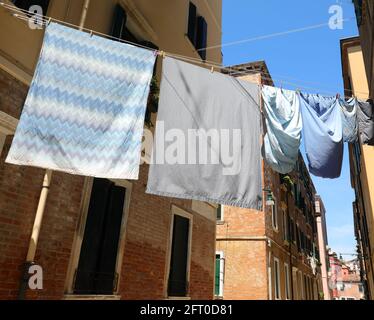 beaucoup de vêtements accrochés à sécher au soleil avec Draps et taies d'oreiller dans une ruelle de l'italien île Banque D'Images