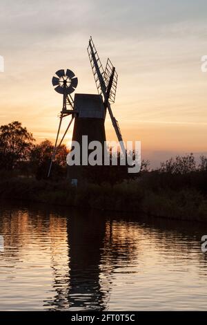 Moulin à vent TURF Fen, How Hill, murmuration étoilée à Sunset, Norfolk, East Anglia, Royaume-Uni Banque D'Images