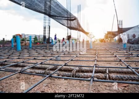 Une attention particulière portée au béton armé, les ouvriers de la construction fabriquent des barres de renfort en acier sur le chantier de construction Banque D'Images