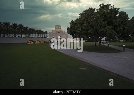 Musée d'art islamique , Doha, Qatar coucher de soleil vue extérieure avec le jardin du musée en premier plan et les nuages dans le ciel en arrière-plan Banque D'Images