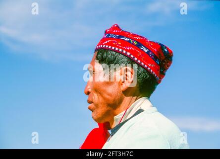 Gros plan d'un péruvien local, d'un boatman sur le lac Titicaca lors d'un voyage de Puno à l'île de Taquile, portant une casquette tricotée traditionnelle rouge Banque D'Images