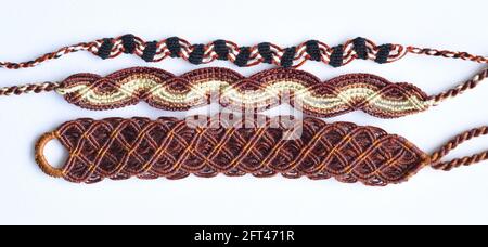 Bracelets d'amitié tissés de bricolage avec différentes tressage dans les couleurs brunes. Accessoires d'été Banque D'Images