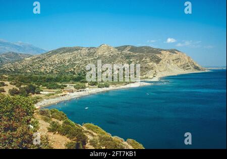 Image d'archivage. La plage Agia Galini en Crète avec les montagnes lointaines, relativement peu développée en 1979 mais il ya un bar de plage avec une zone plate être Banque D'Images