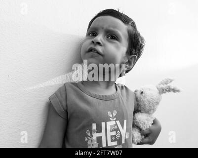 Une vue rapprochée d'une fille indienne tenant un jouet en monochrome, Kalaburagi, Karnatka, Inde-mai 10.2021 Banque D'Images