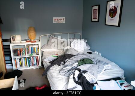 Adolescent garçon 15 16 chambre en désordre draps de lit non faits vêtements mur bleu GCSE étude livres d'école livre ordinateur 2021 au Royaume-Uni Grande-Bretagne KATHY DEWITT Banque D'Images