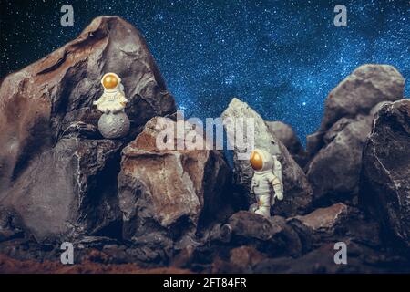 Astronautes avec visière dorée et combinaison blanche sur la surface rocheuse avec arrière-plan spatial. Premier astronaute sur la lune assis et méditant pendant la seconde Banque D'Images