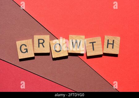 Croissance, mot en lettres de l'alphabet en bois isolées sur fond rouge Banque D'Images