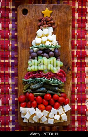 Arbre de Noël des hors-d'œuvre: Amandes, fromage, olives, raisins, salami, concombre mariné, tomates. Concept de la nourriture de Noël. Banque D'Images