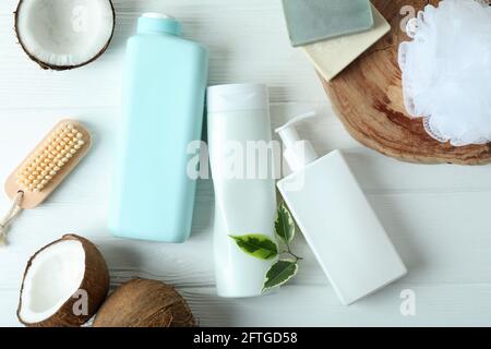 Cosmétiques de bain et noix de coco sur fond de bois blanc Banque D'Images